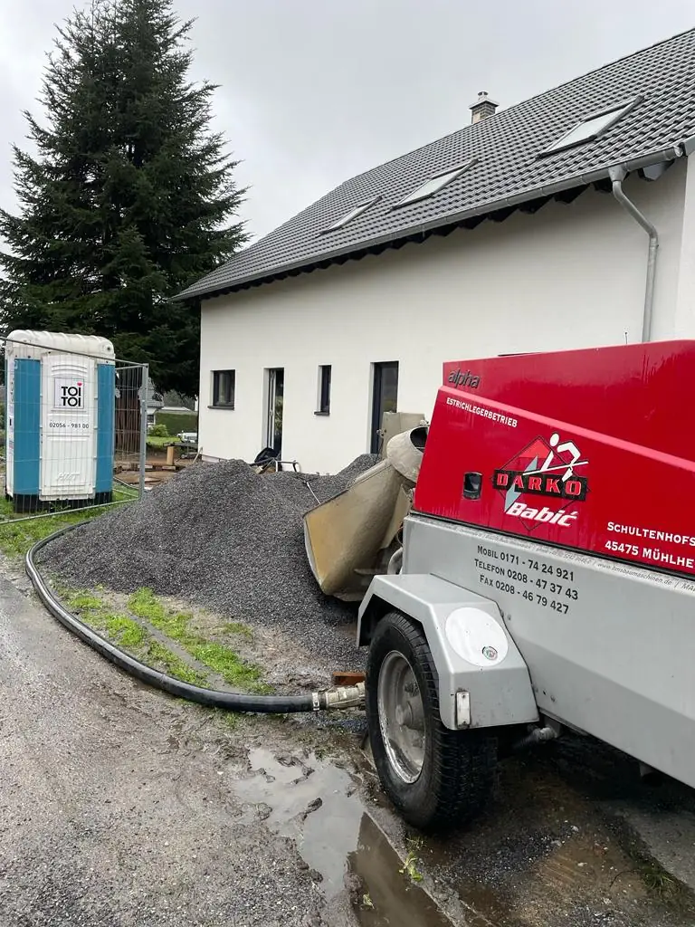 Rote Estrichpumpe von Darko Babić an einem Neubau mit Material für den Estrich