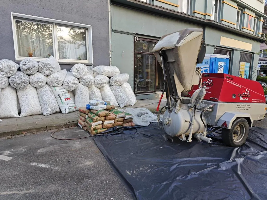 Rote Estrichpumpe von Darko Babić mit Material auf einer Baustelle in der Stadt